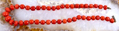 Lot 61 - A red coral beaded necklace with 9ct gold clasp.