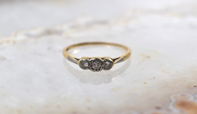 Lot 54 - An 18ct gold and three stone diamond ring,...