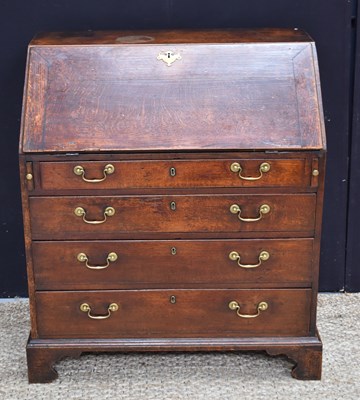 Lot 604 - A Georgian oak bureau with four graduated...