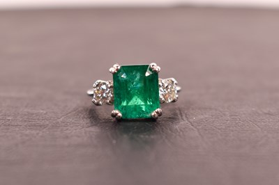 Lot 85 - A platinum, diamond and emerald ring, the...