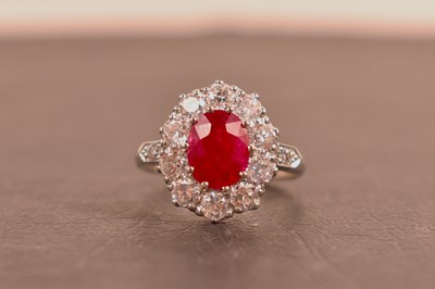 Lot 135 - A platinum, diamond and ruby ring, the oval...
