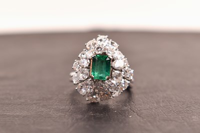 Lot 86 - A platinum, diamond and emerald cluster ring,...