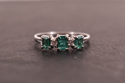 Lot 97 - A platinum, diamond and emerald ring, the...